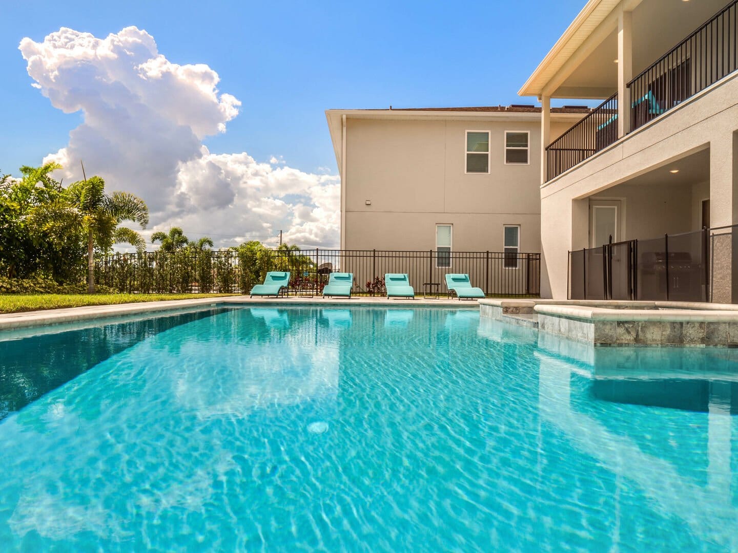 Backyard pool with lounge chairs.