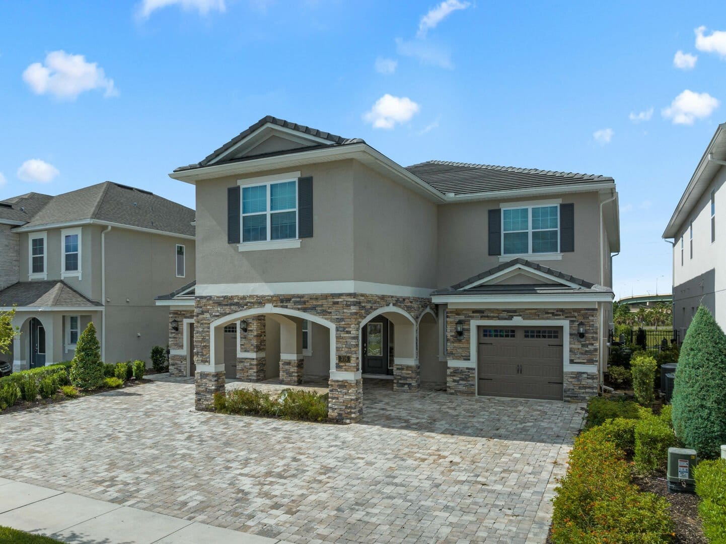 Two-story house with stone accents.