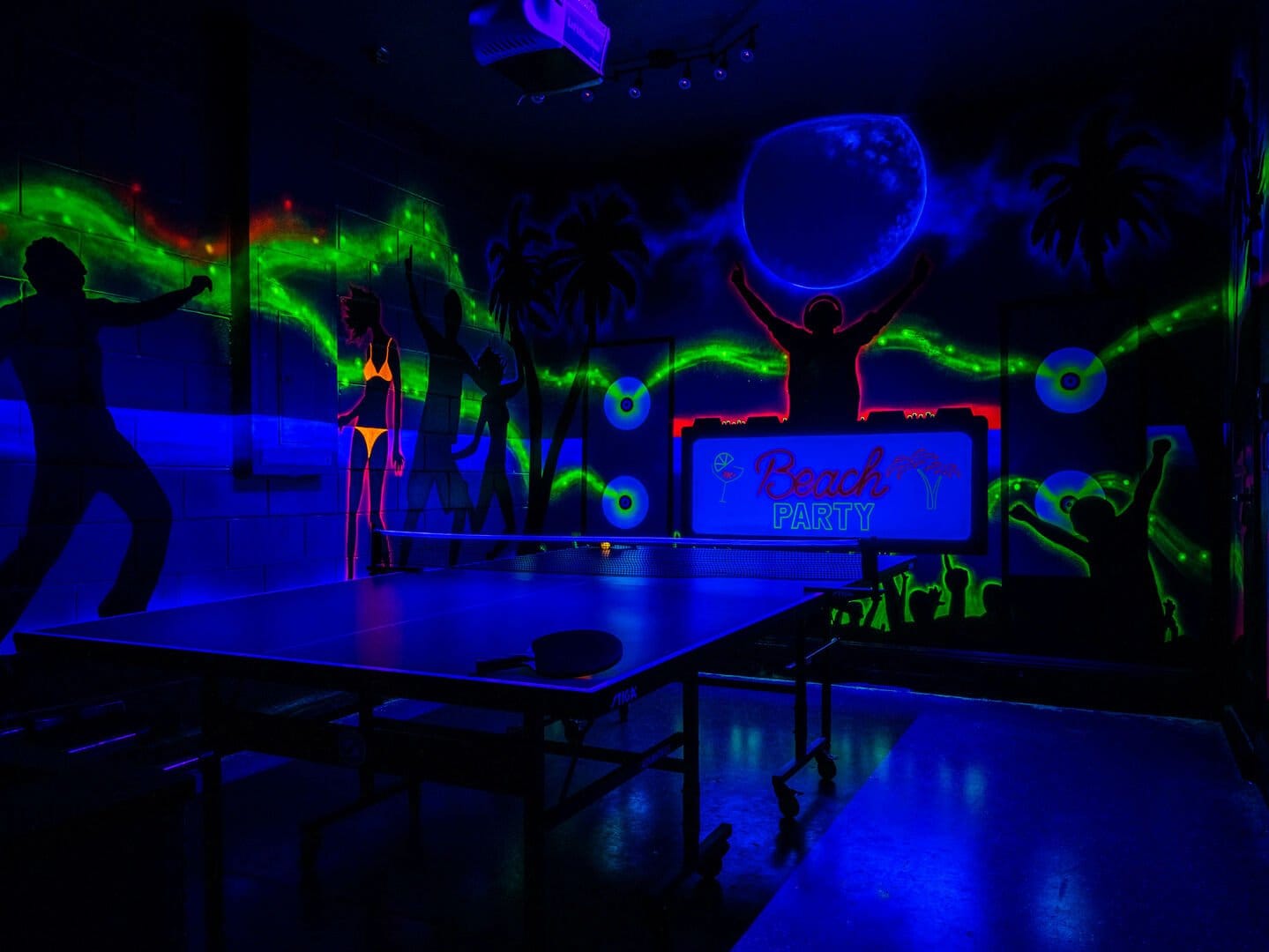 Neon beach party room with table.