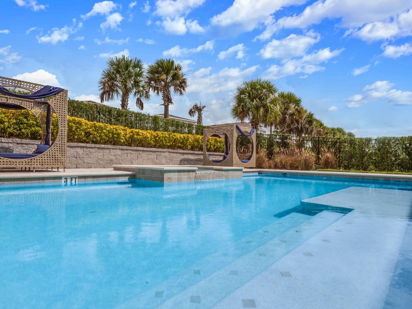 Luxurious pool with cabanas, palms.