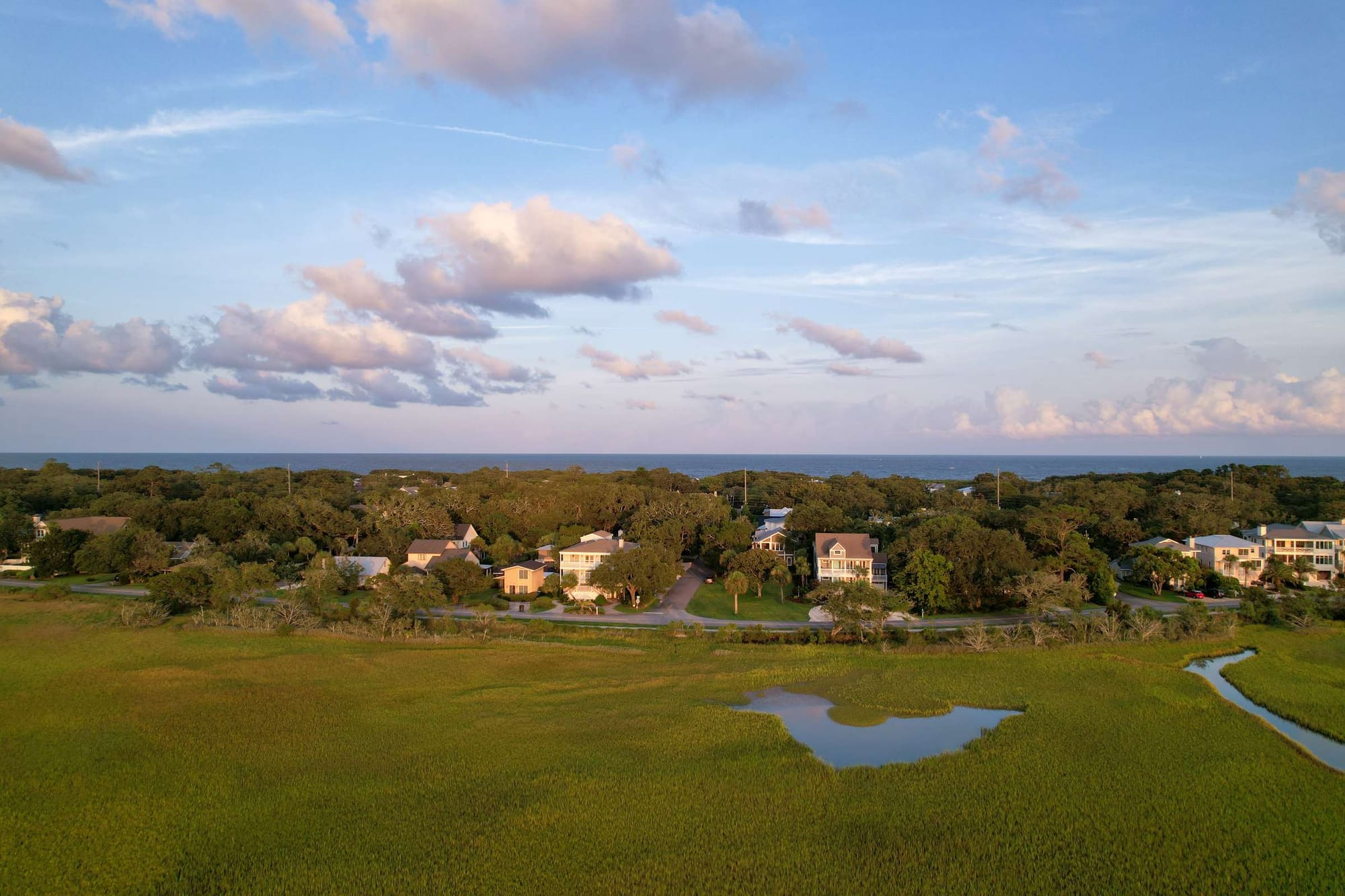 Houses by the sea, green fields.