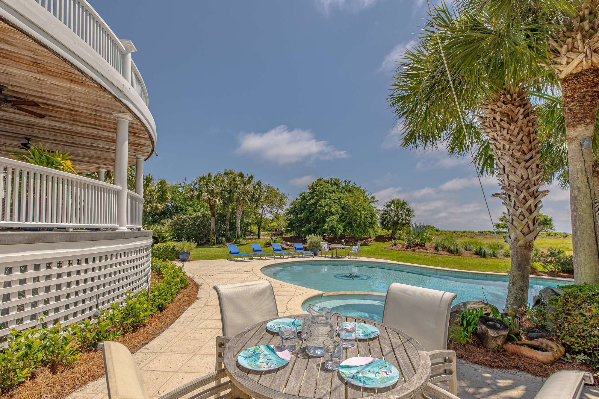 Outdoor poolside dining with palm trees