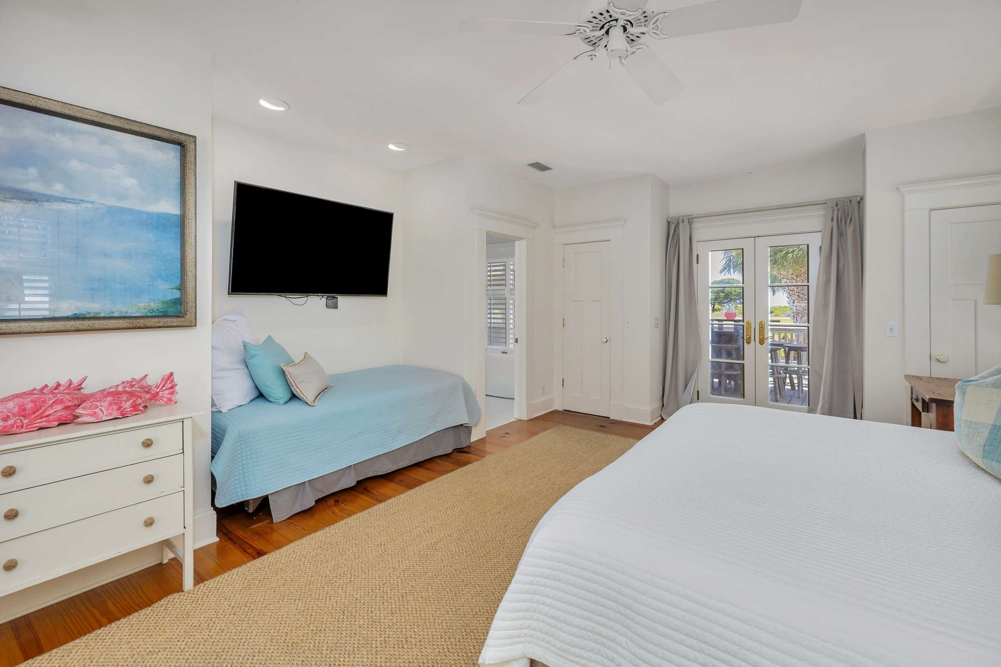 Bright bedroom with TV and balcony.