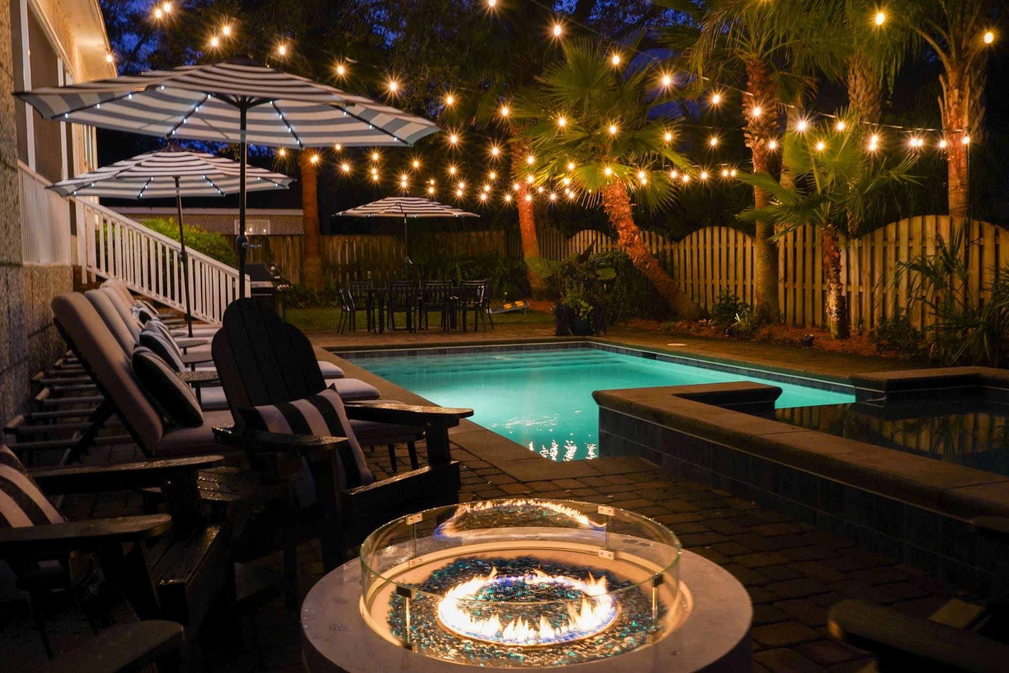 Outdoor pool and firepit at night.