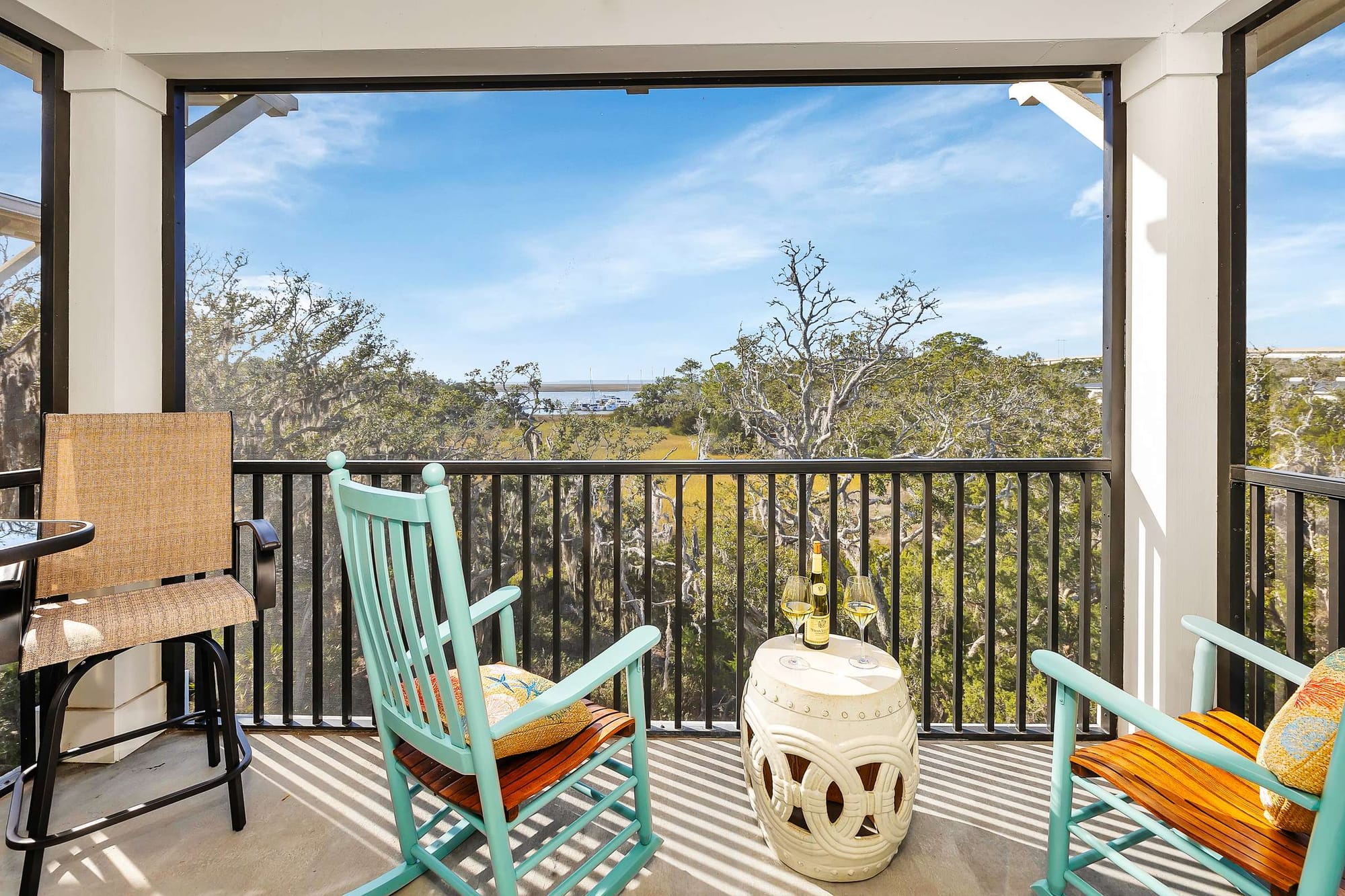 Balcony with chairs, table, view.