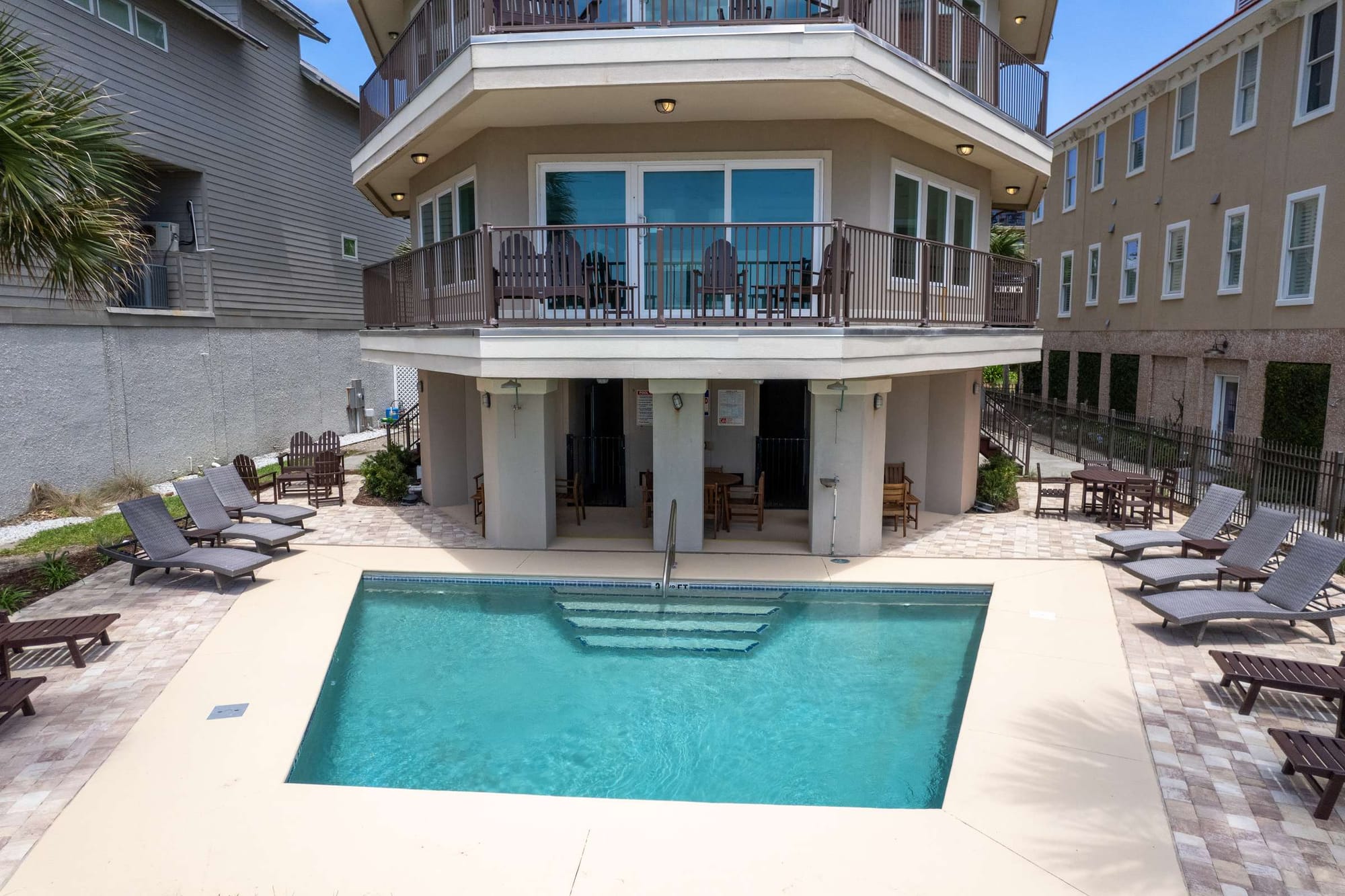 House with pool and lounge chairs.