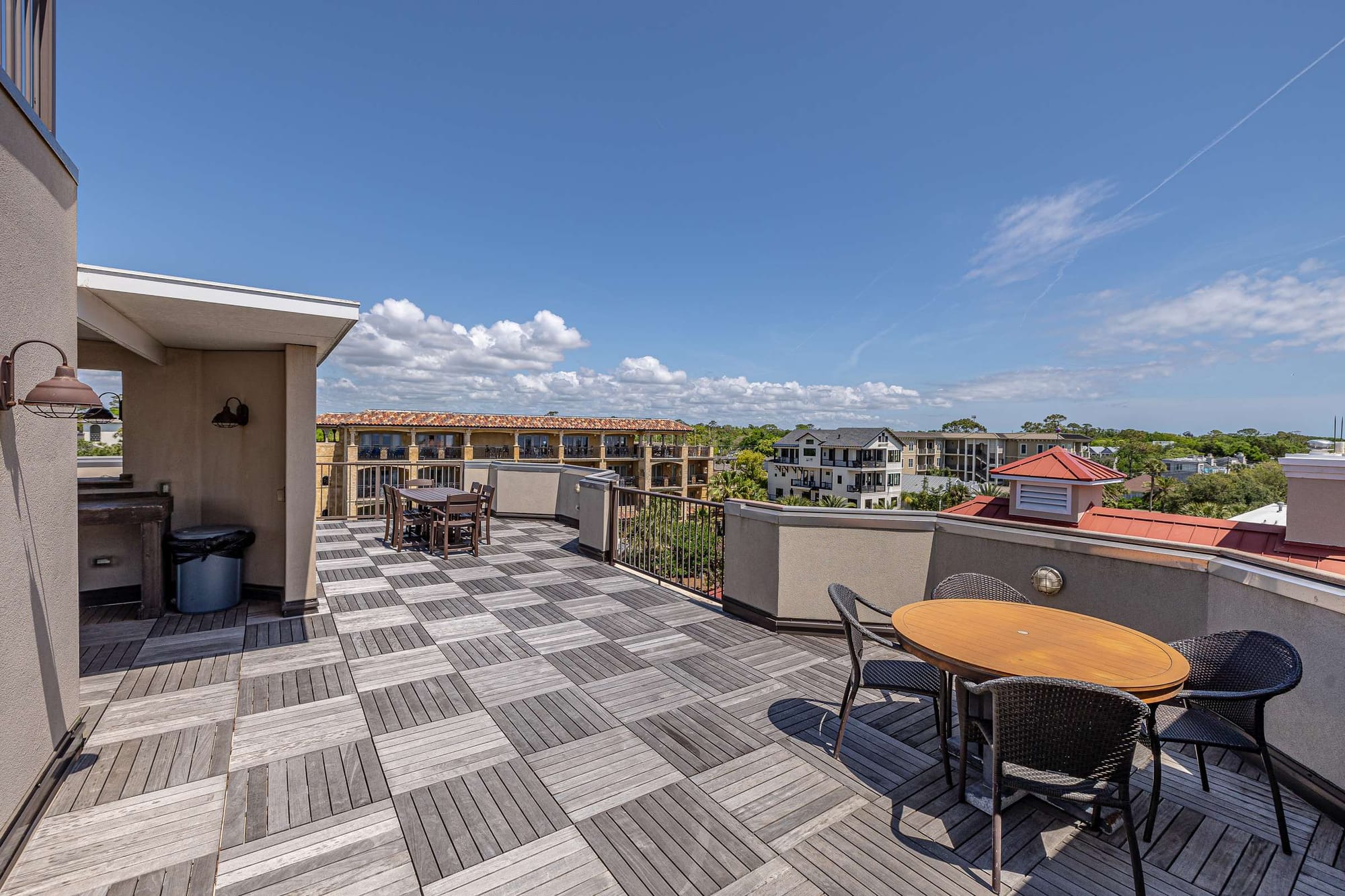 Rooftop patio with tables, chairs.