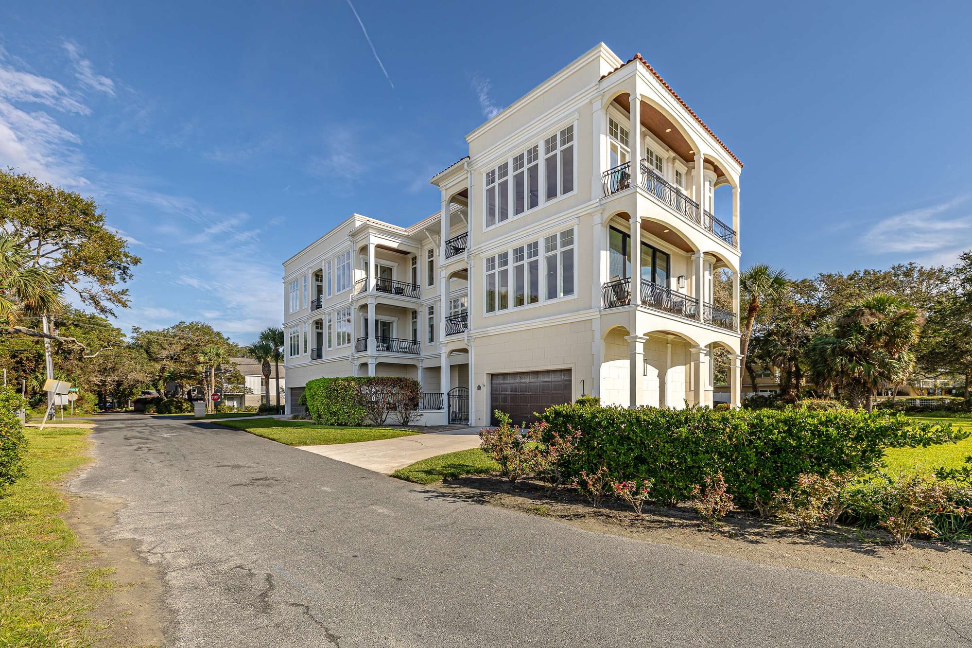 Three-story modern house, sunny day.