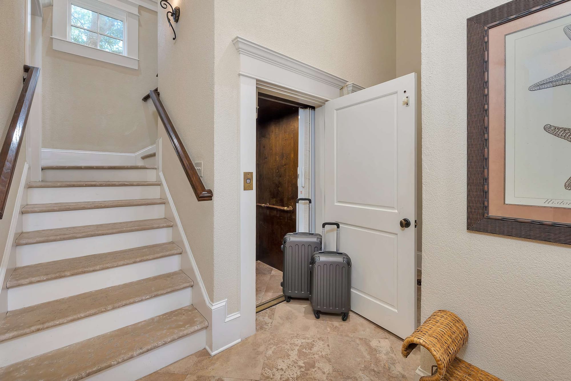 Home elevator beside staircase, suitcases nearby.