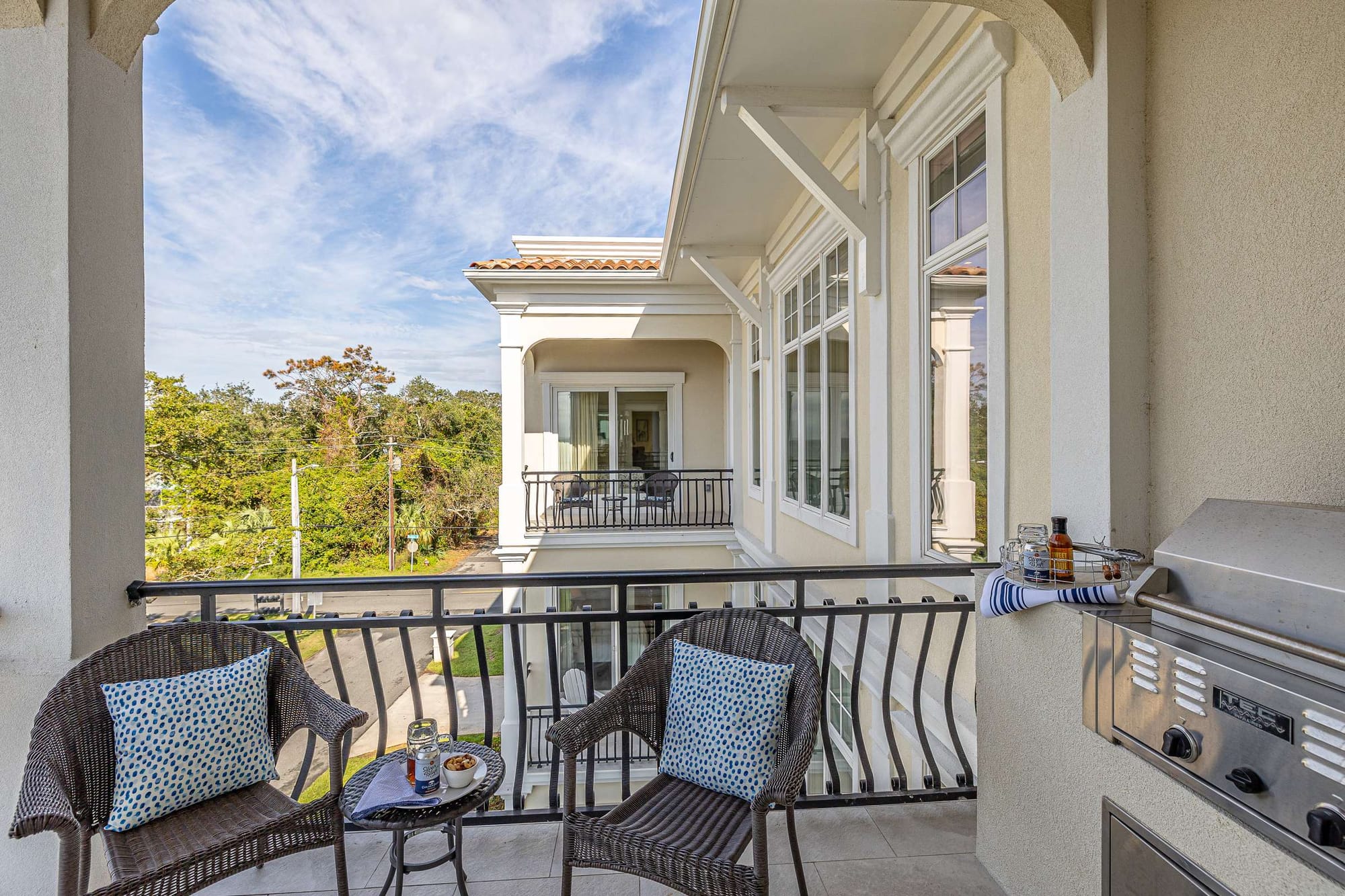 Outdoor balcony with seating, grill.