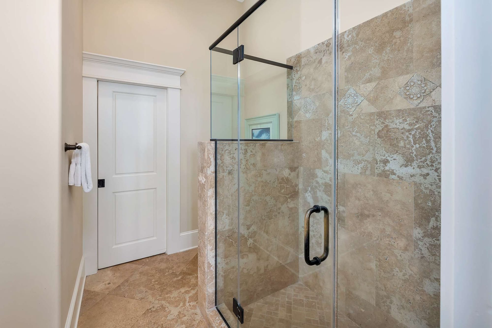 Modern shower with beige tiles.