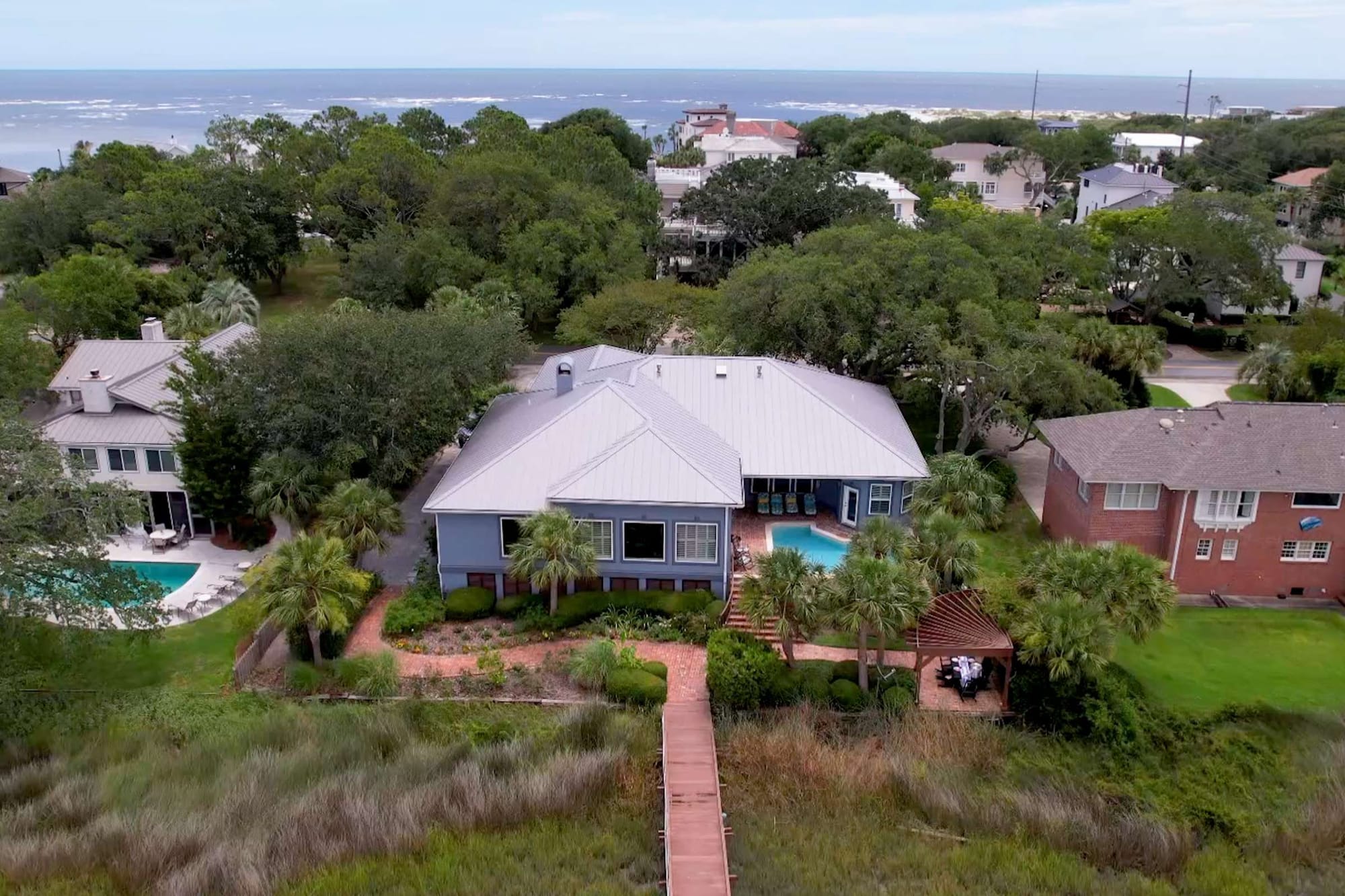 Seaside house with surrounding greenery.