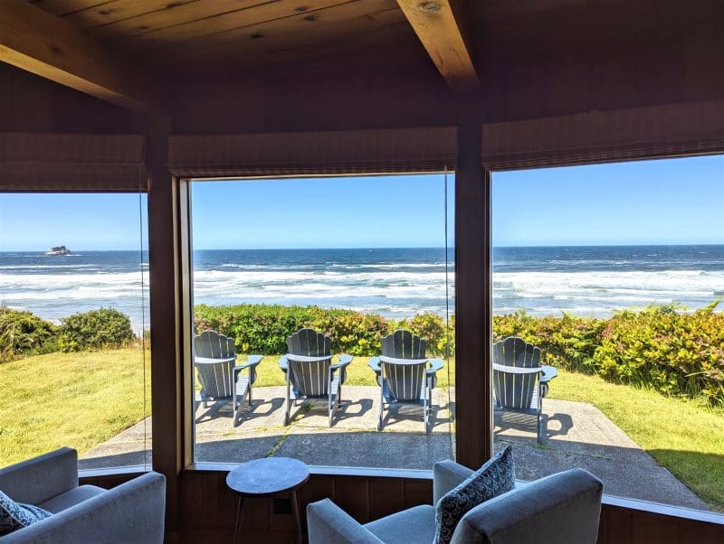 Ocean view through window with chairs.