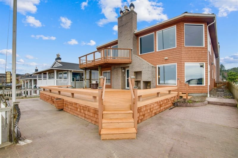 Two-story house with wooden deck.