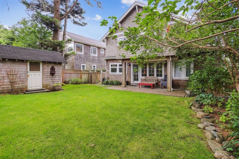 Green backyard with a wooden house.