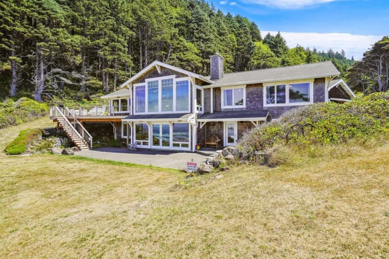 Lakeside house with forest backdrop.