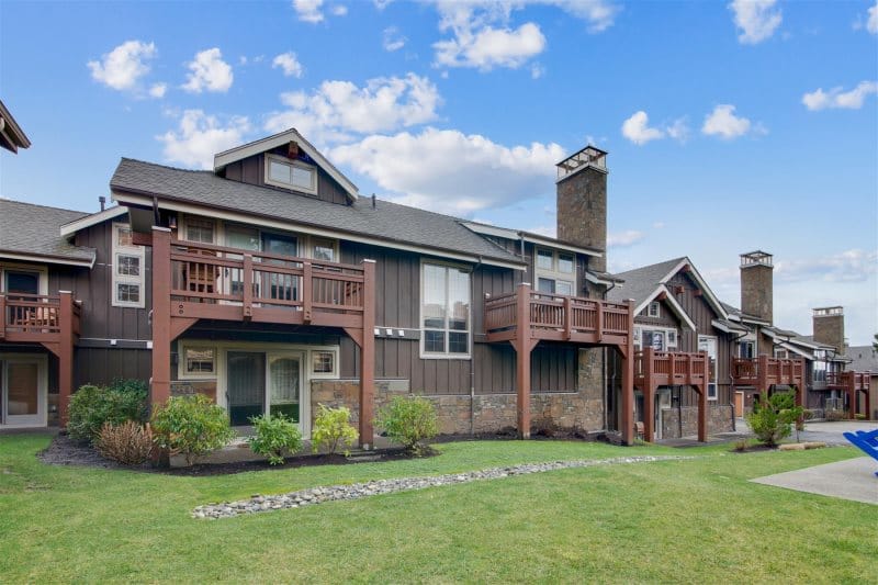 Two-story townhouse with wooden balconies.