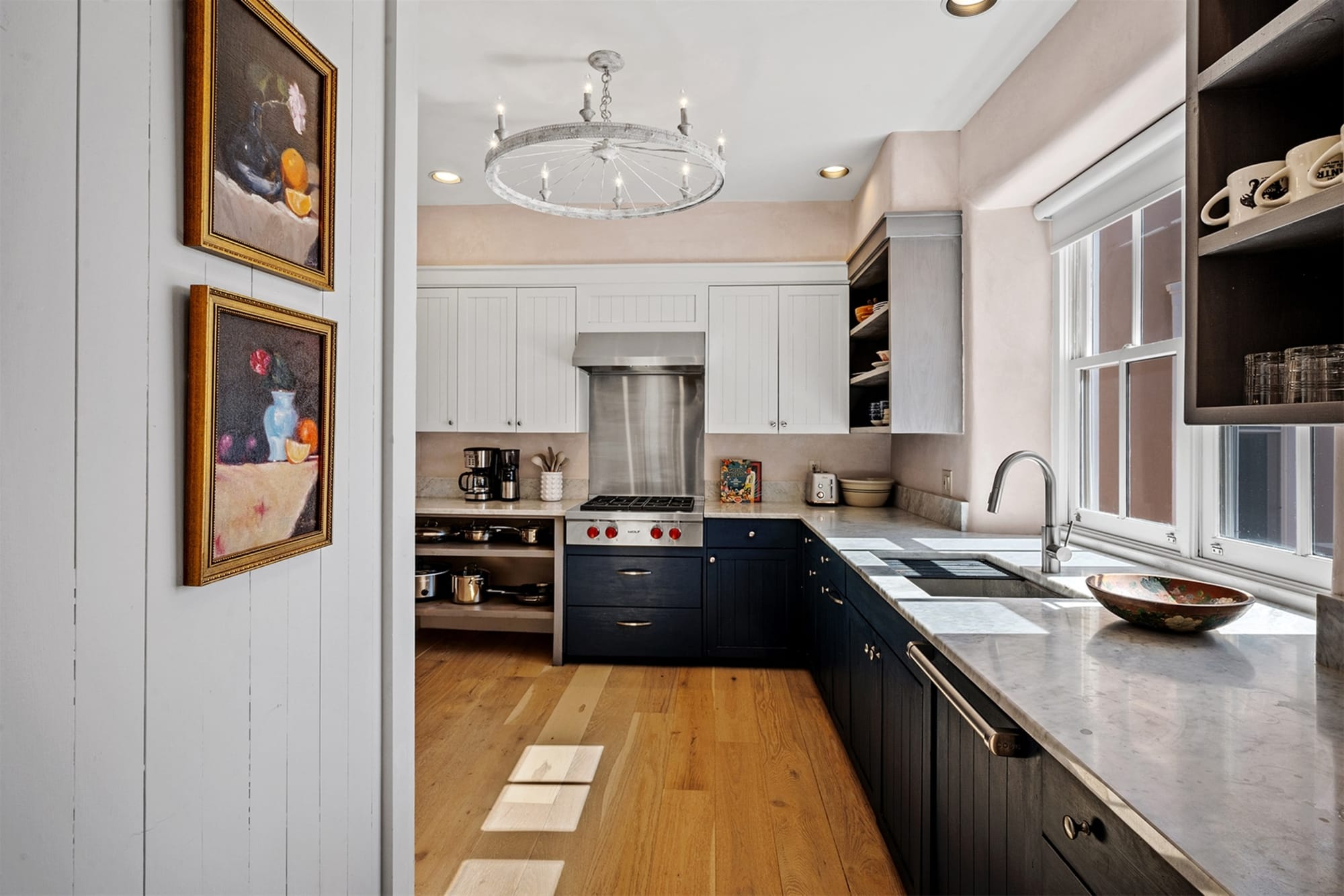 Modern kitchen with paintings, hardwood floor.