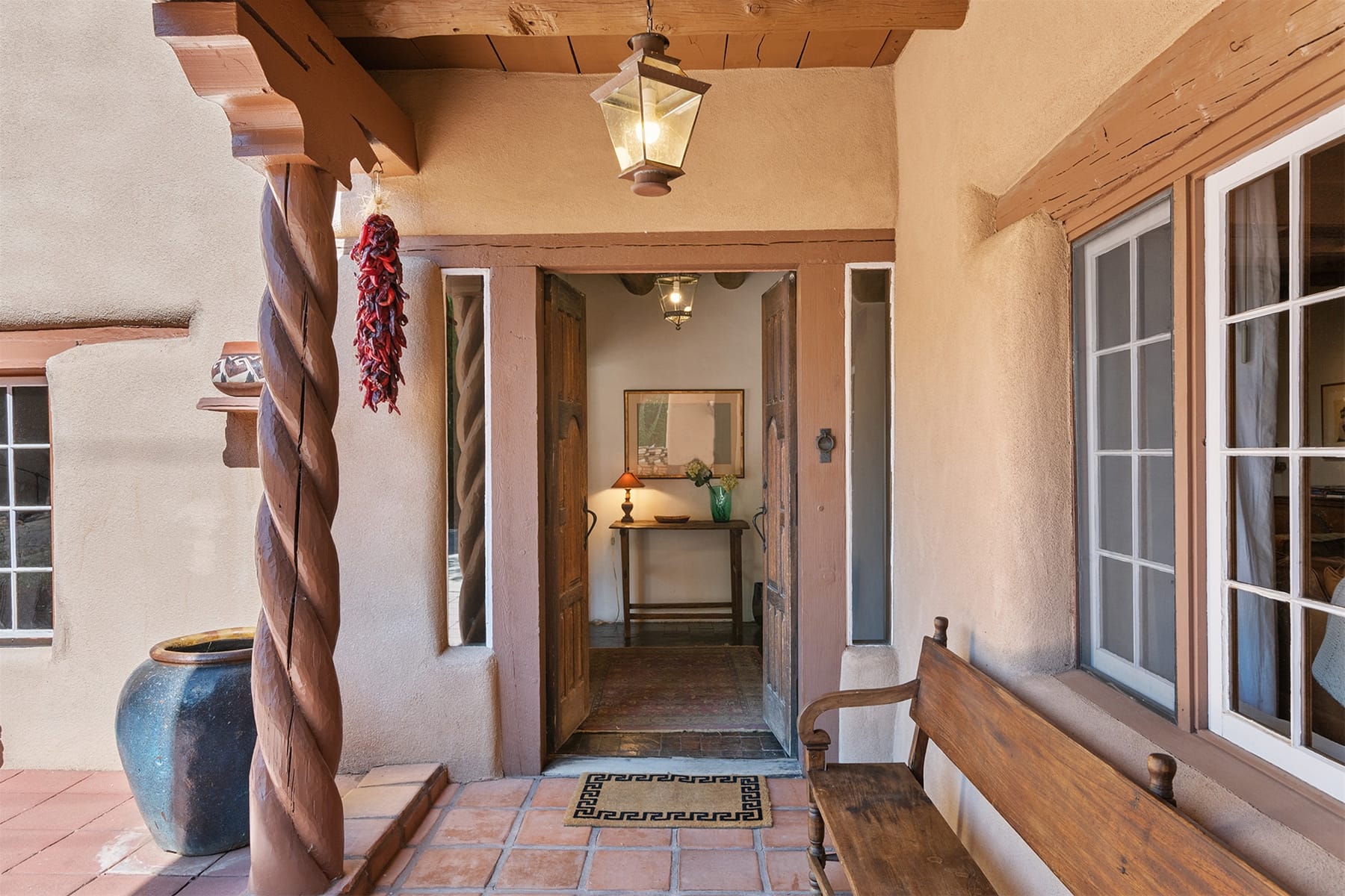 Southwestern-style entrance with wooden bench.