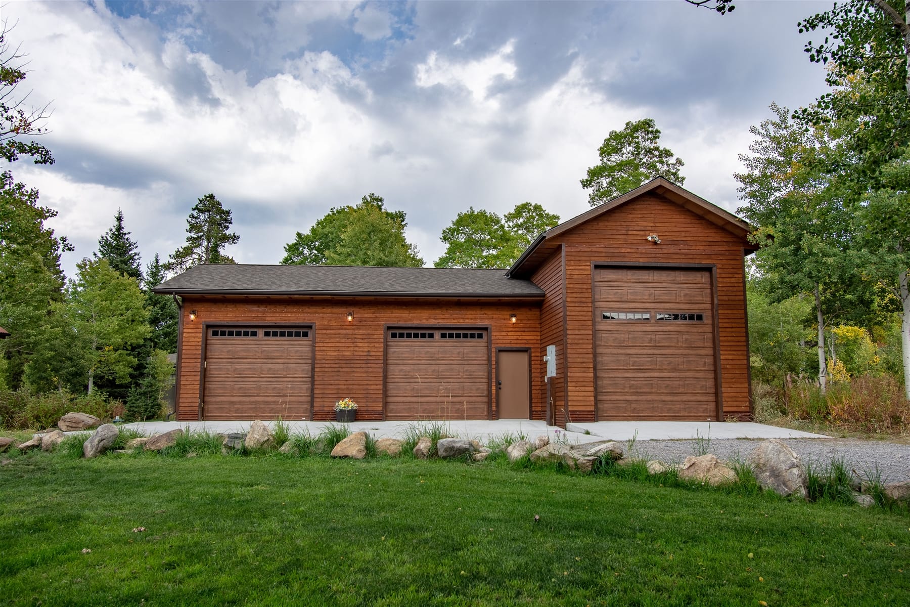 Wooden garage and greenery.