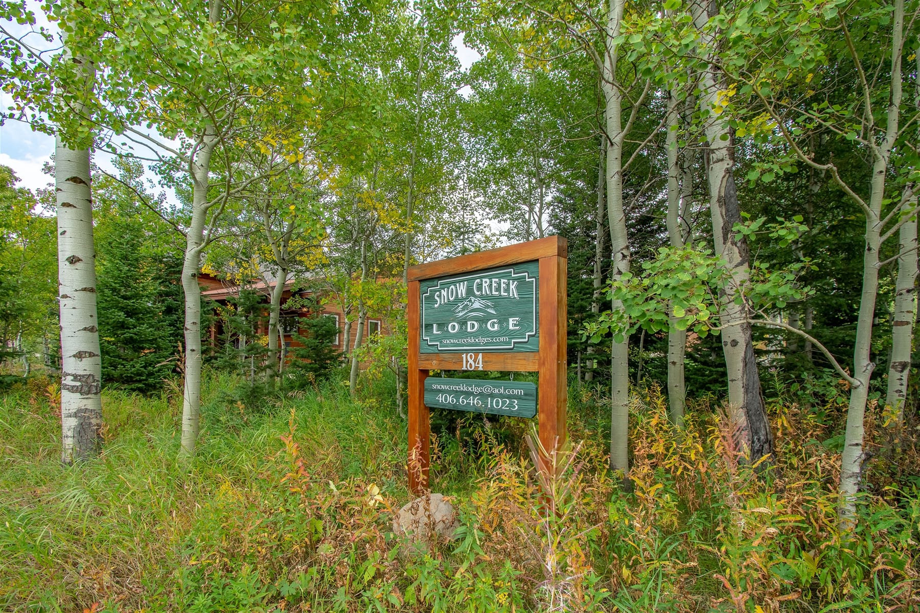 Snow Creek Lodge sign in forest.