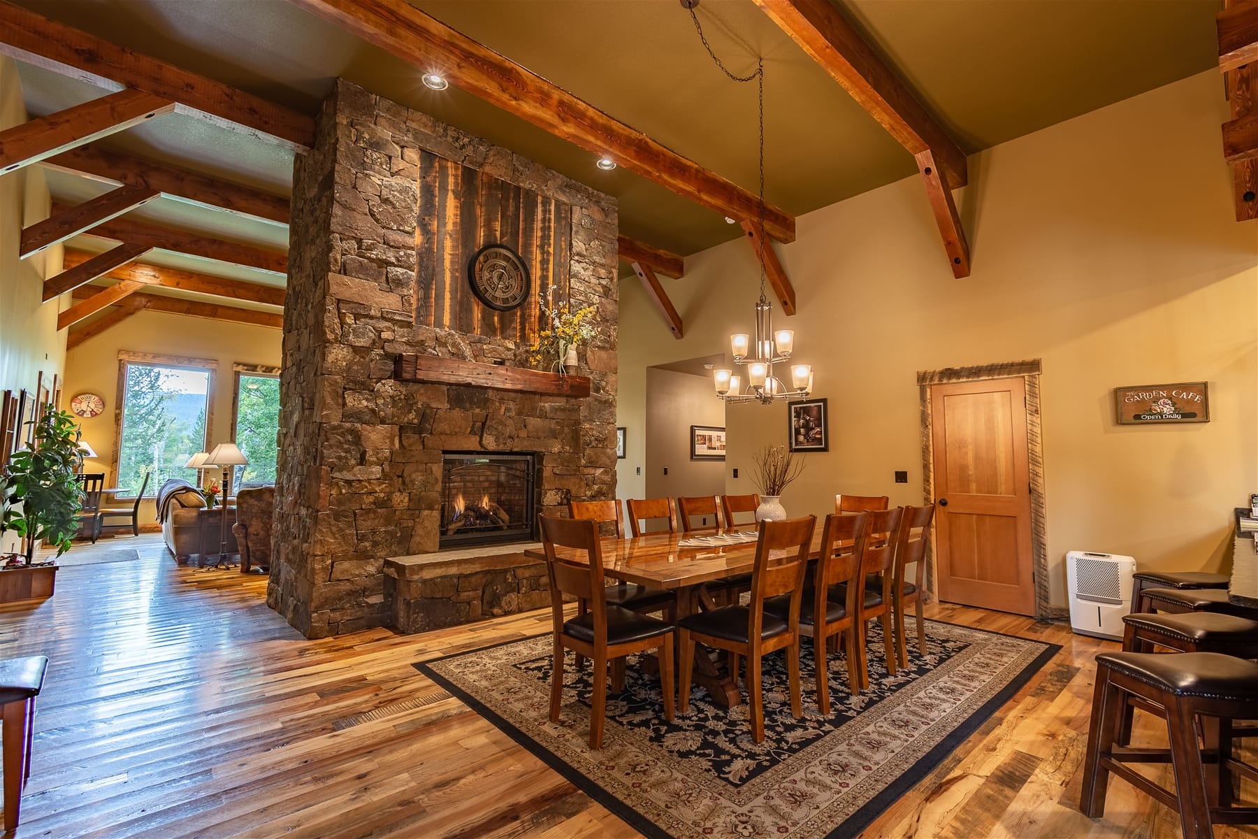 Rustic dining room with stone fireplace.