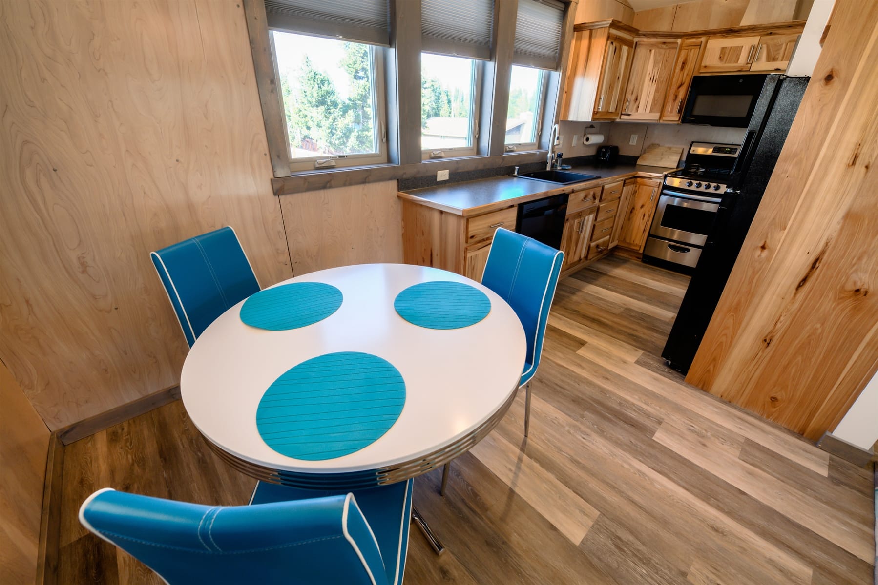 Modern kitchen with blue chairs.