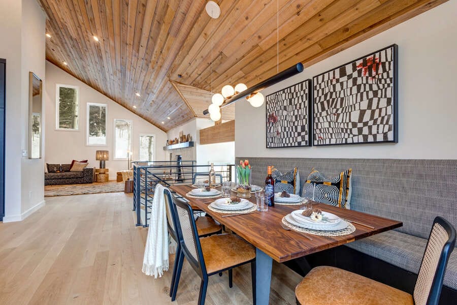 Modern dining area with wooden ceiling.