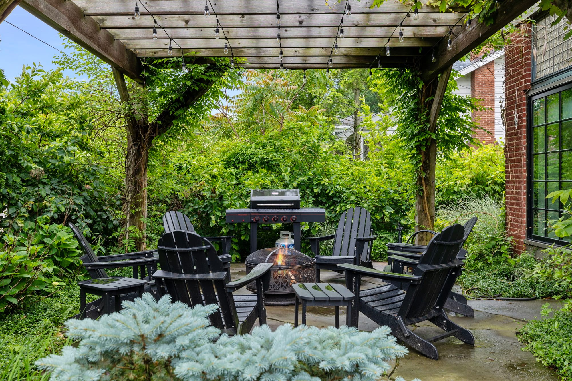 Garden patio with chairs and grill.