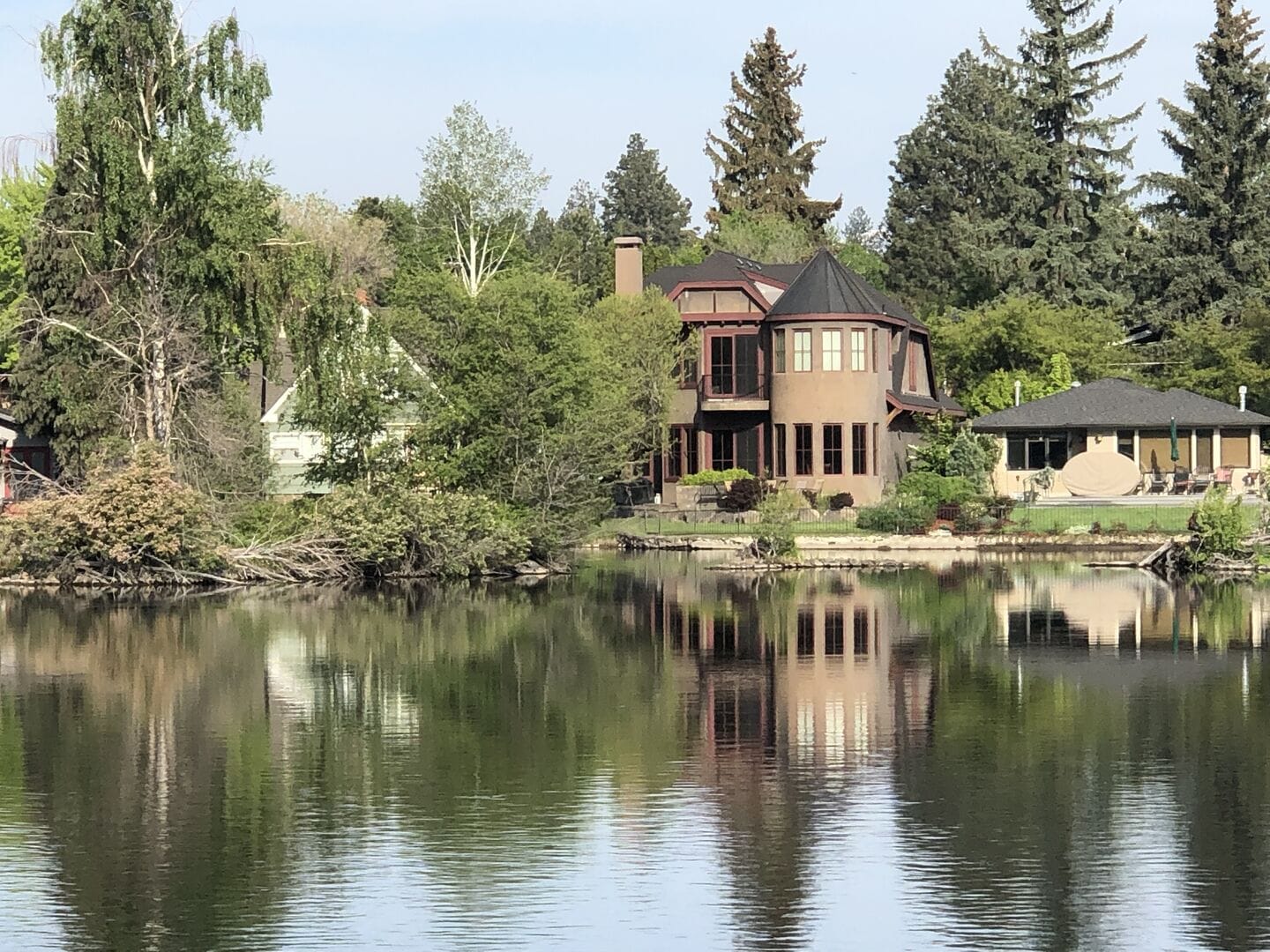 Houses reflected in calm lake.