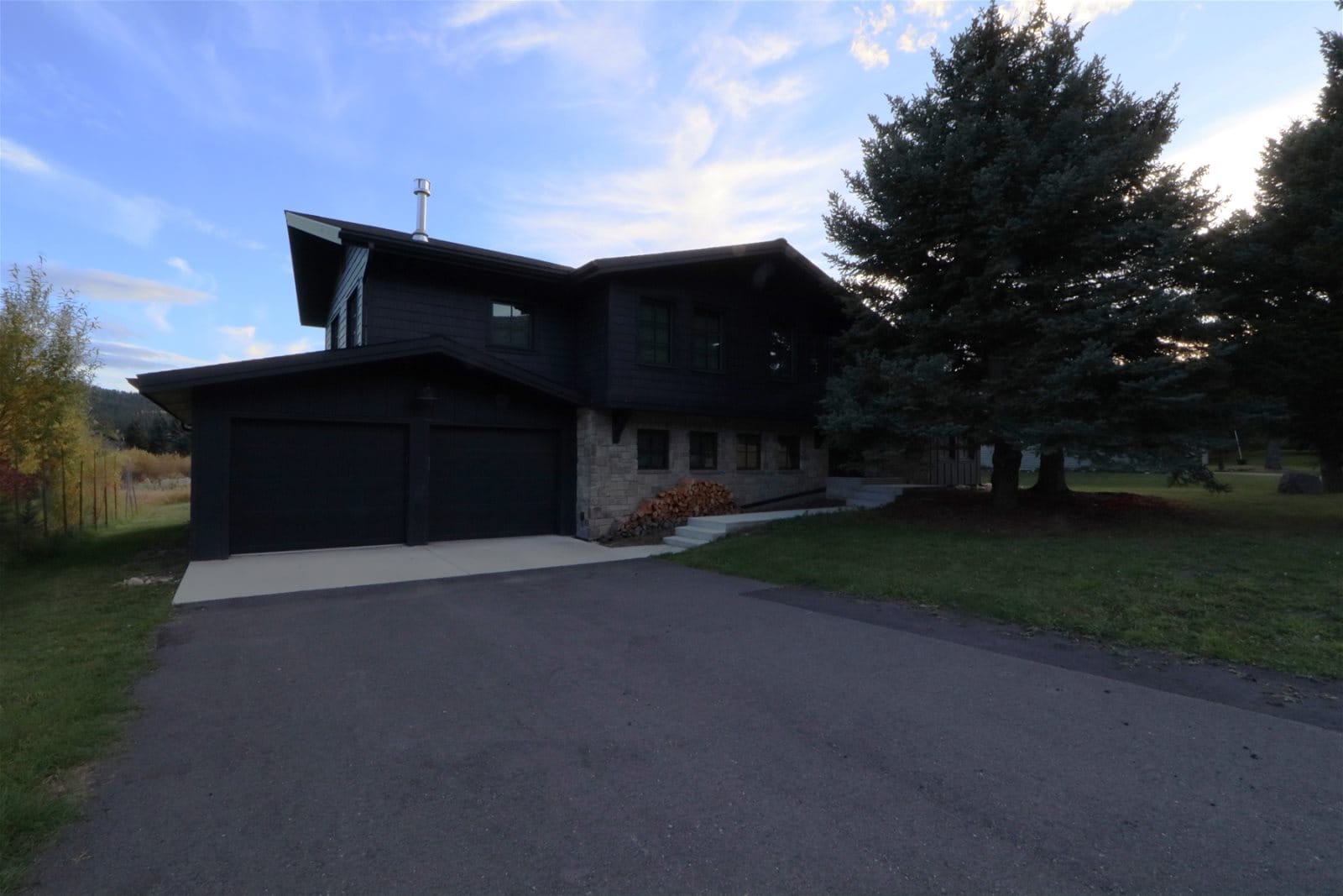 Modern house with garage and trees.