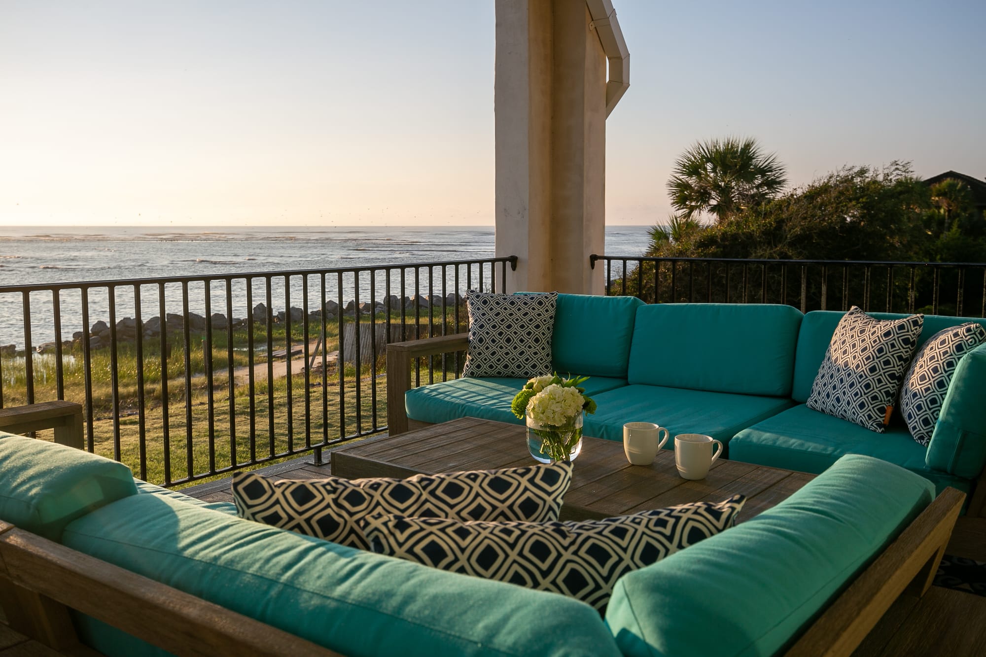 Oceanfront patio with turquoise cushions.