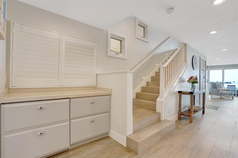 Modern hallway with staircase and cabinets.