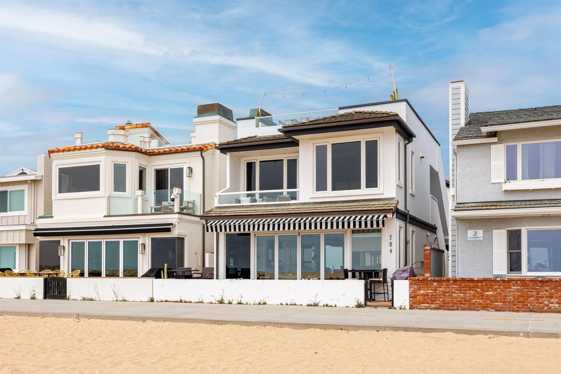 Beachfront houses with large windows.