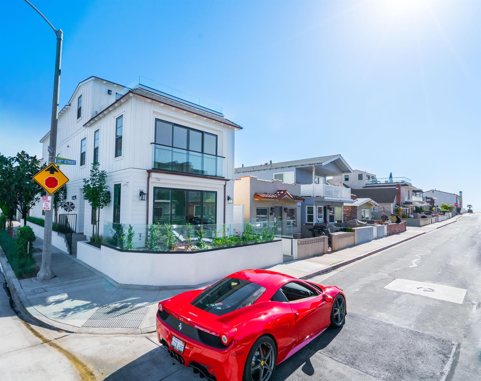 Red car parked near modern houses.