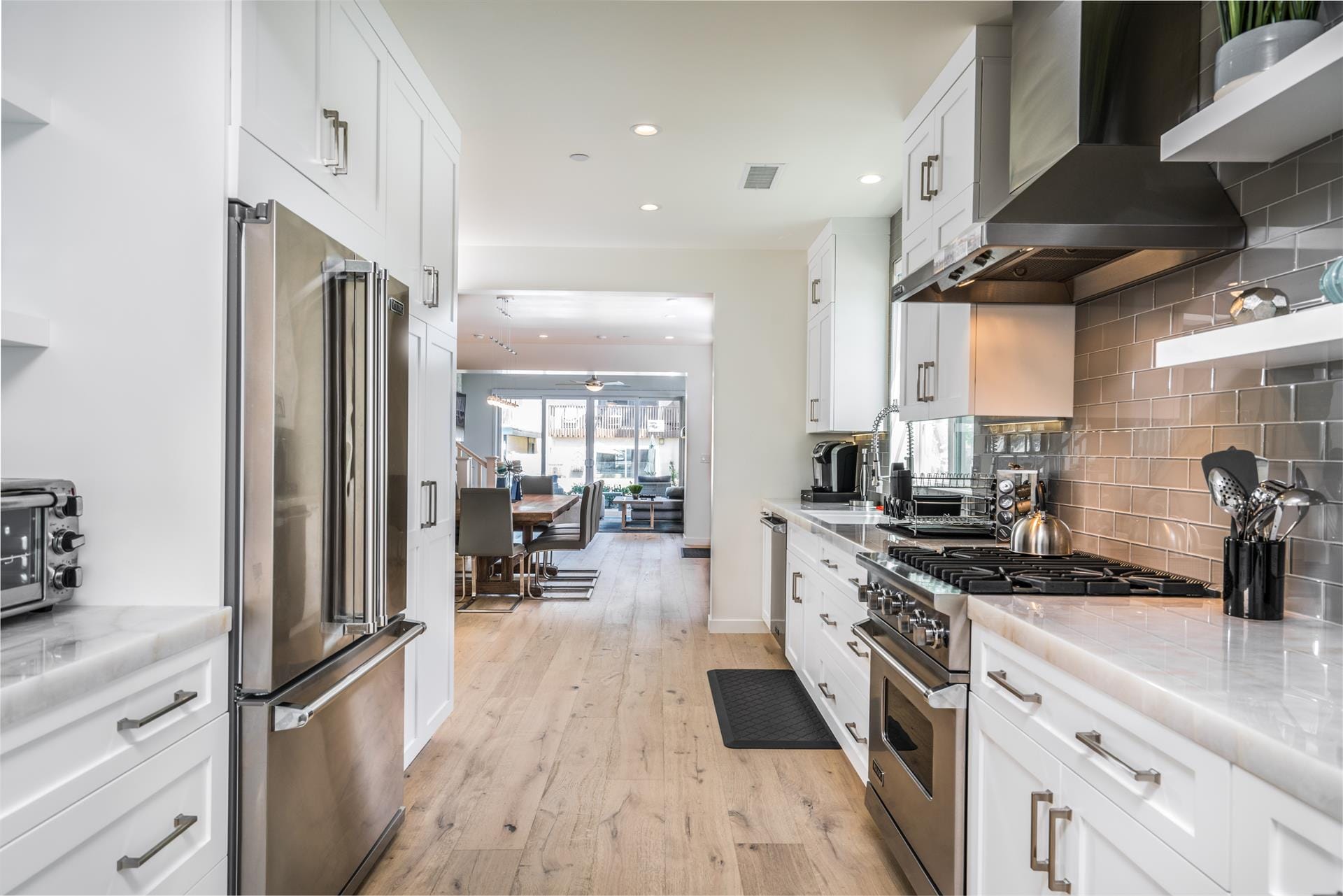 Modern kitchen leading to dining area.