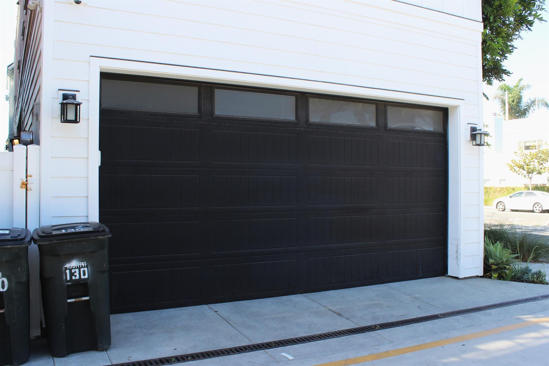 Black garage door with trash cans