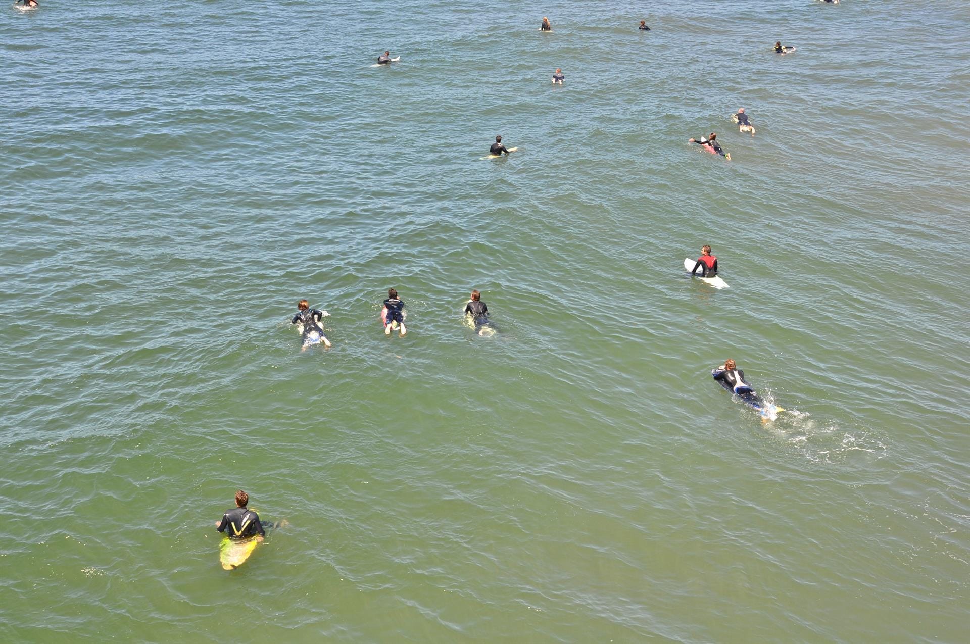 Surfers paddling and waiting for waves.