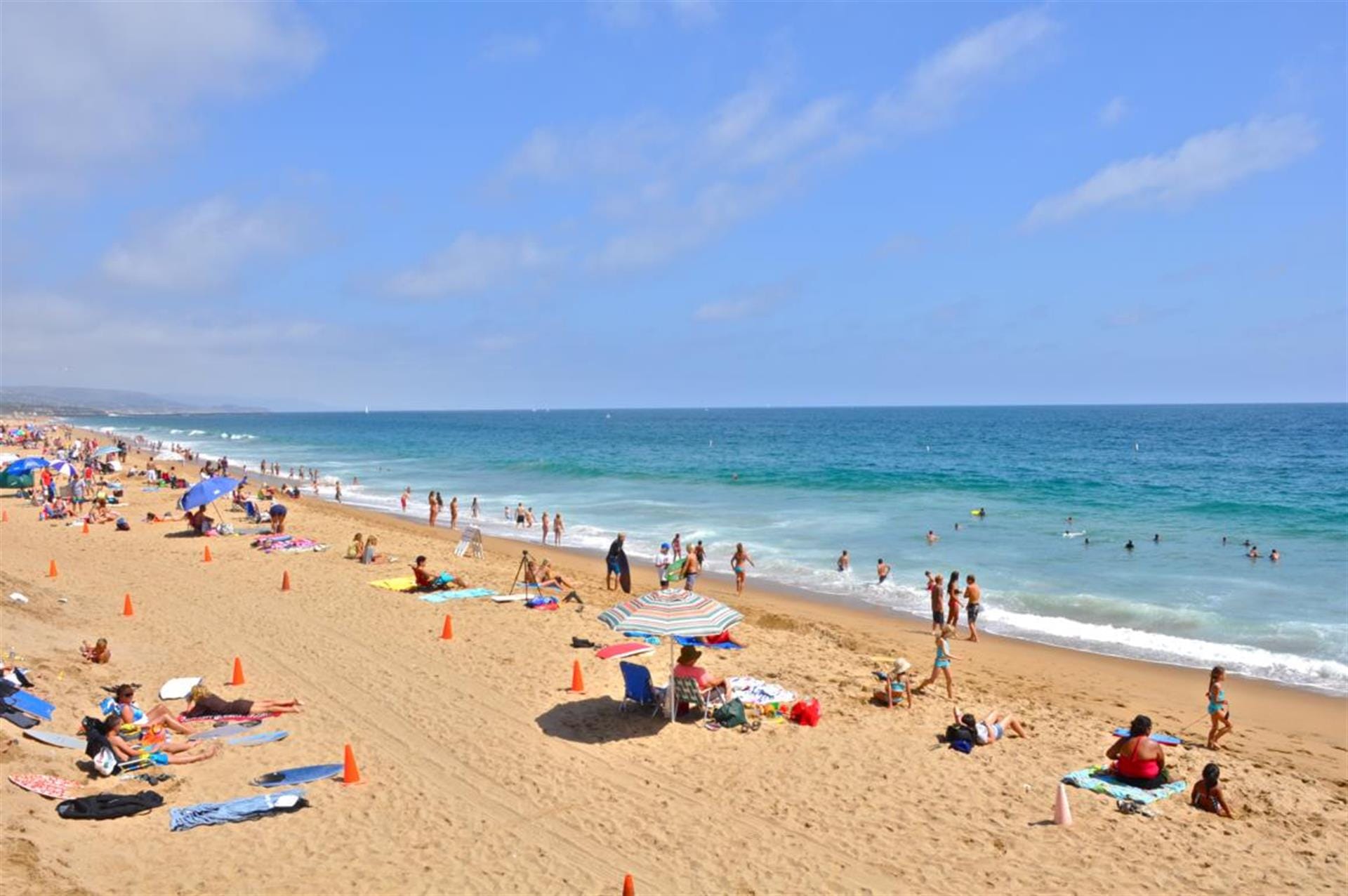 Crowded beach with umbrellas and people