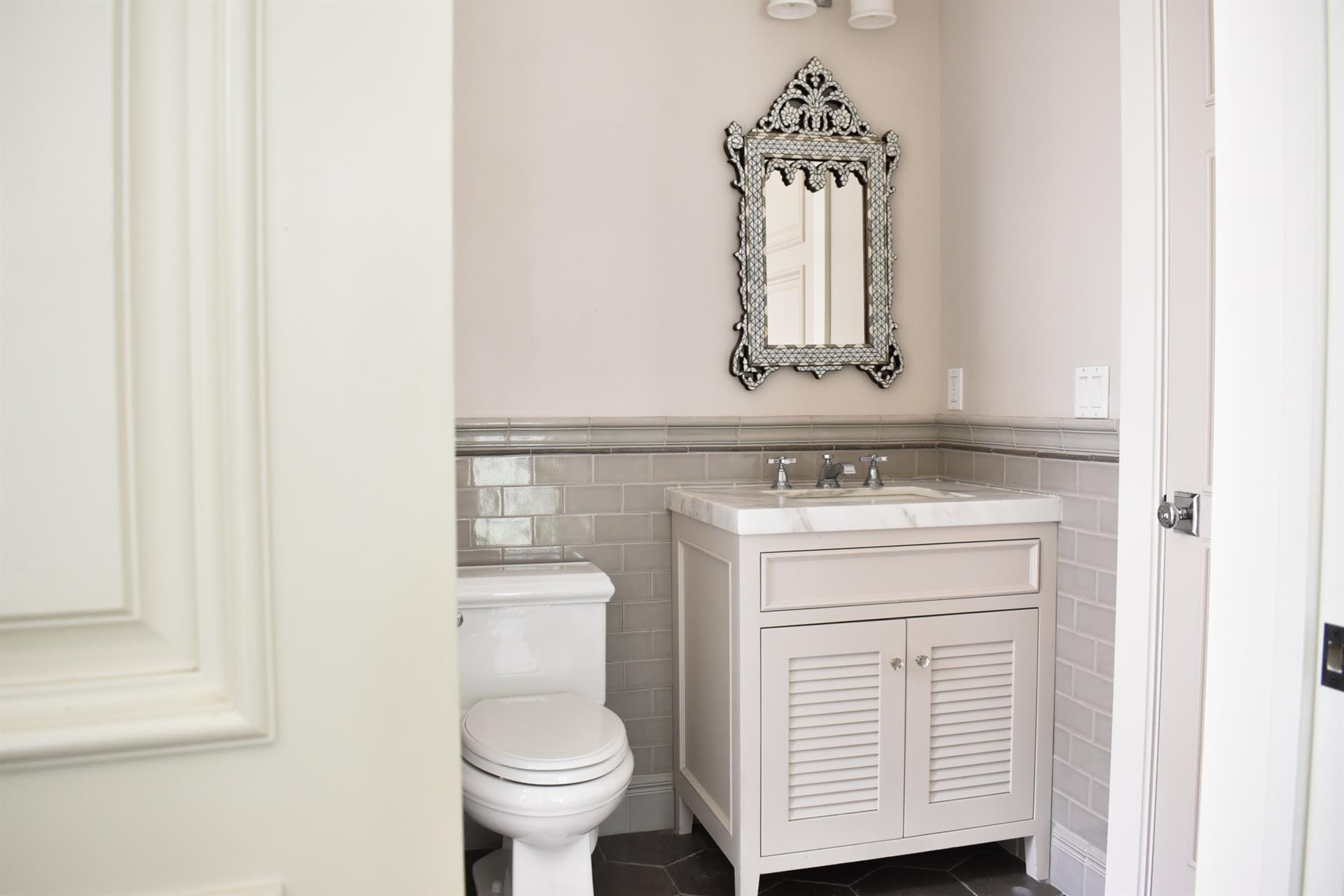 Elegant bathroom with ornate mirror.