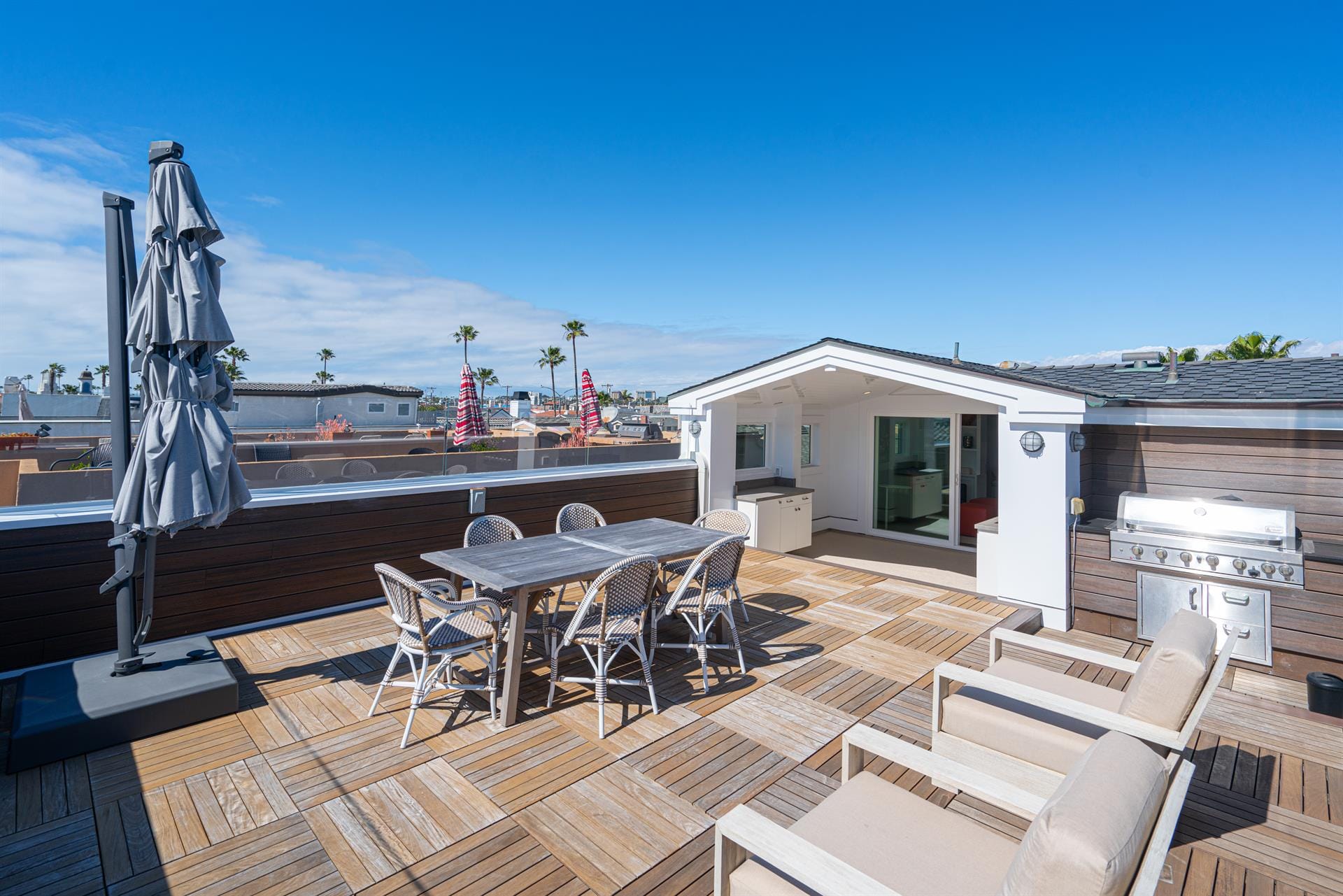 Rooftop patio with furniture, grill.