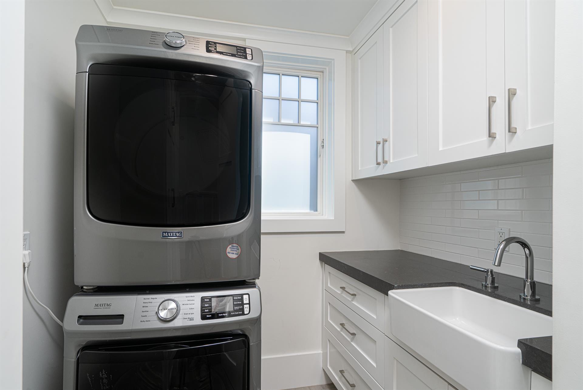 Modern laundry room with stacked machines.