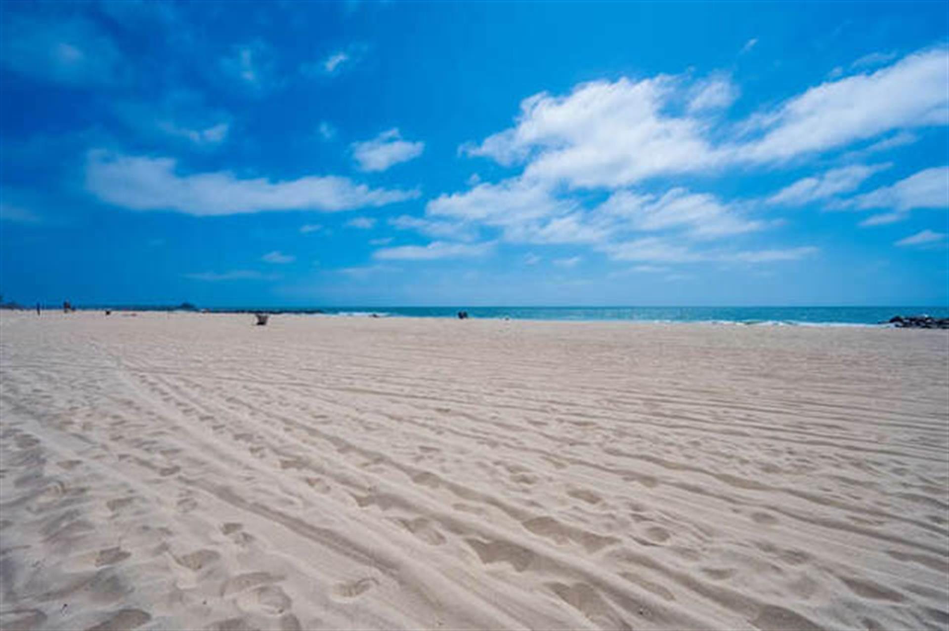 Sunny beach with clear blue sky.