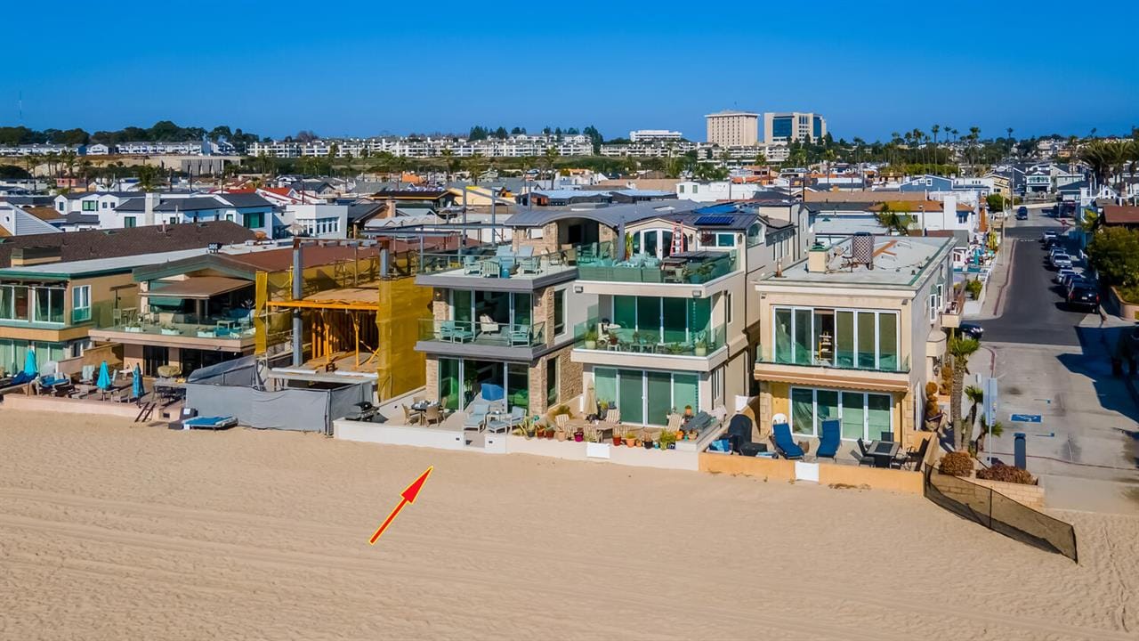 Beachfront homes with sandy shore.