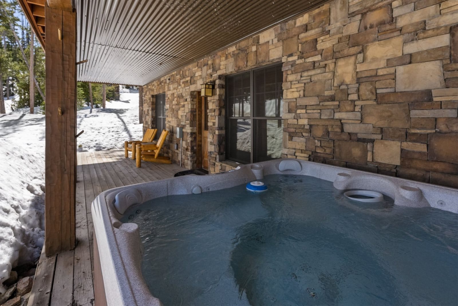 Outdoor hot tub on snowy patio.