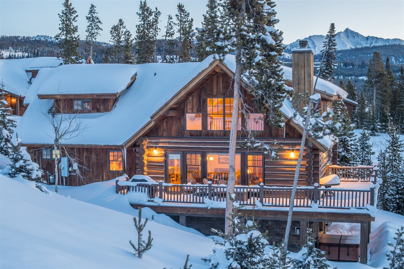 Snow-covered cabin in winter landscape.