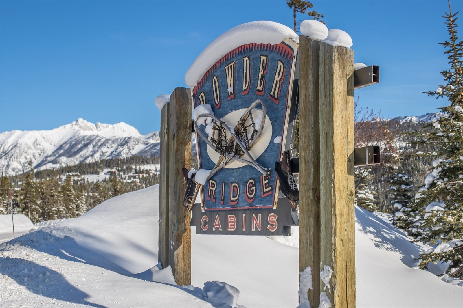 Powder Ridge Cabins sign snowy.