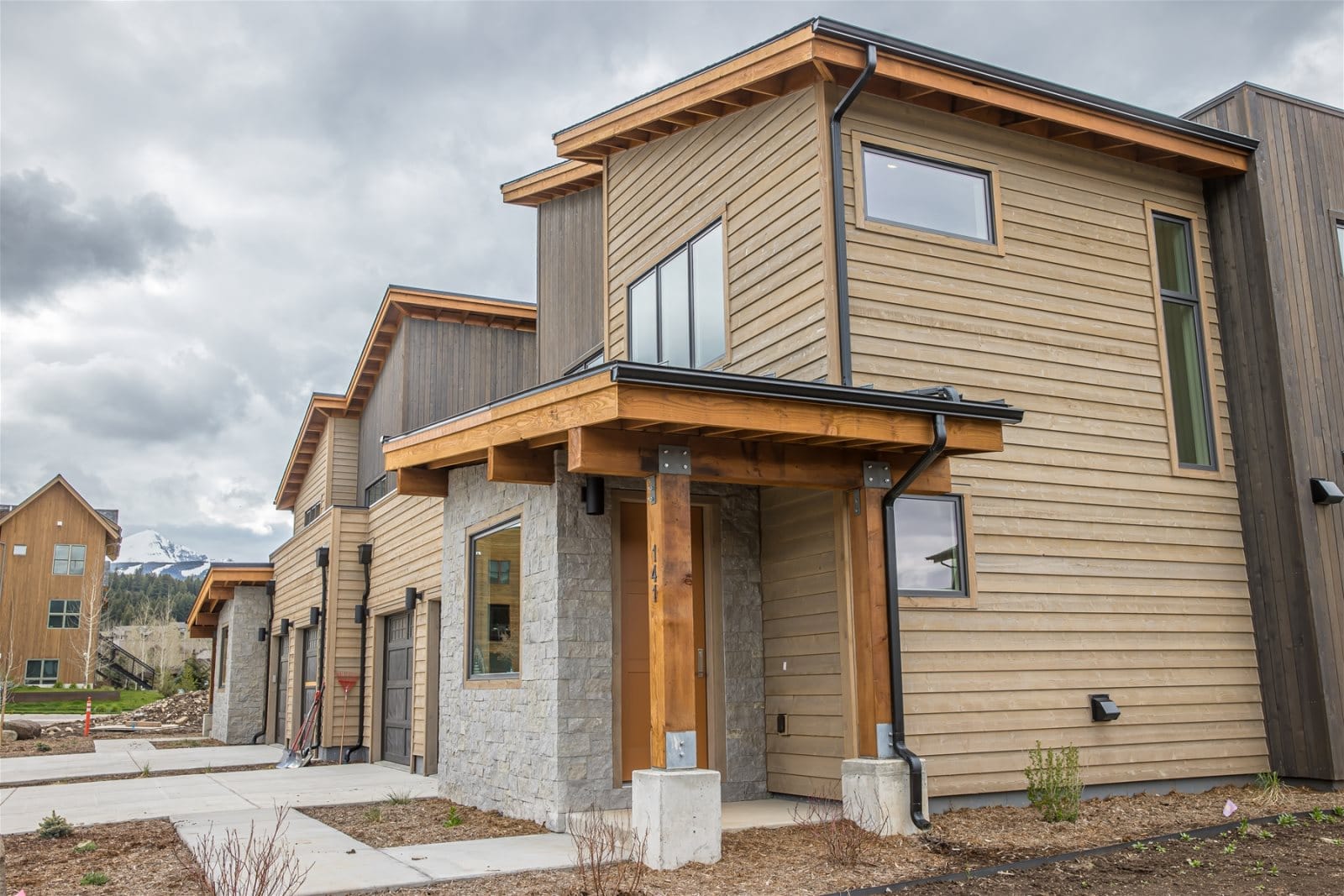 Modern wooden townhouse with porch.