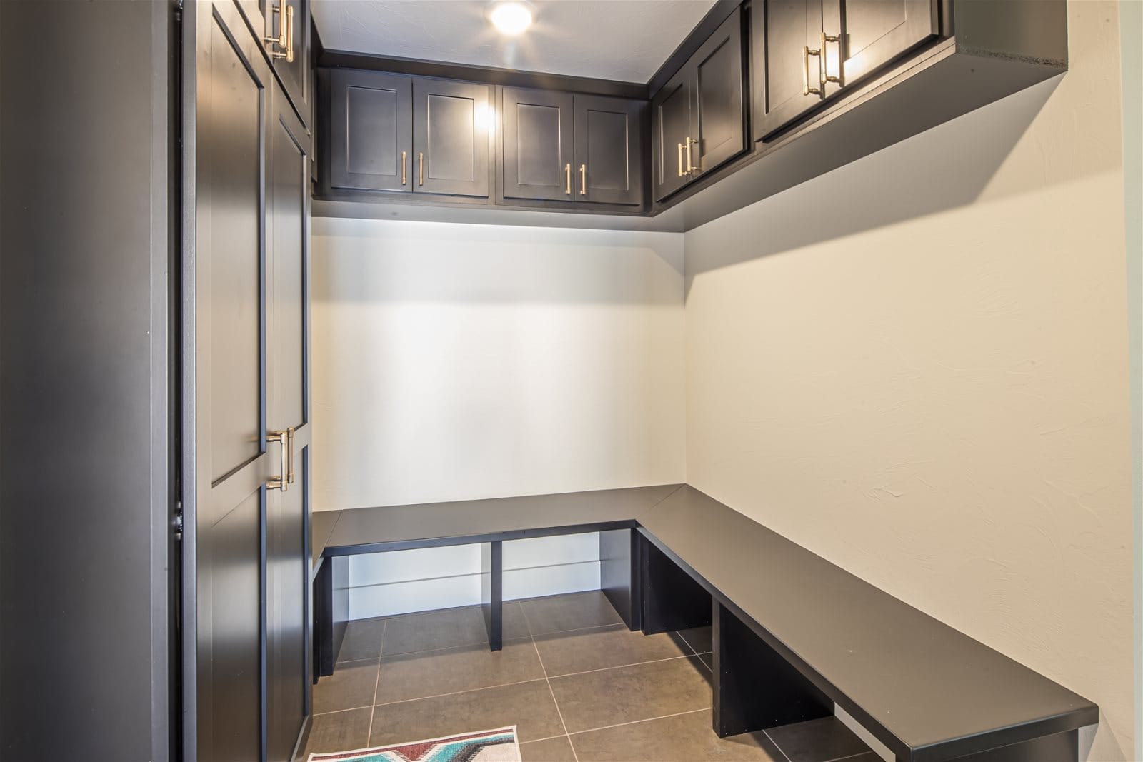 Modern mudroom with dark cabinets.