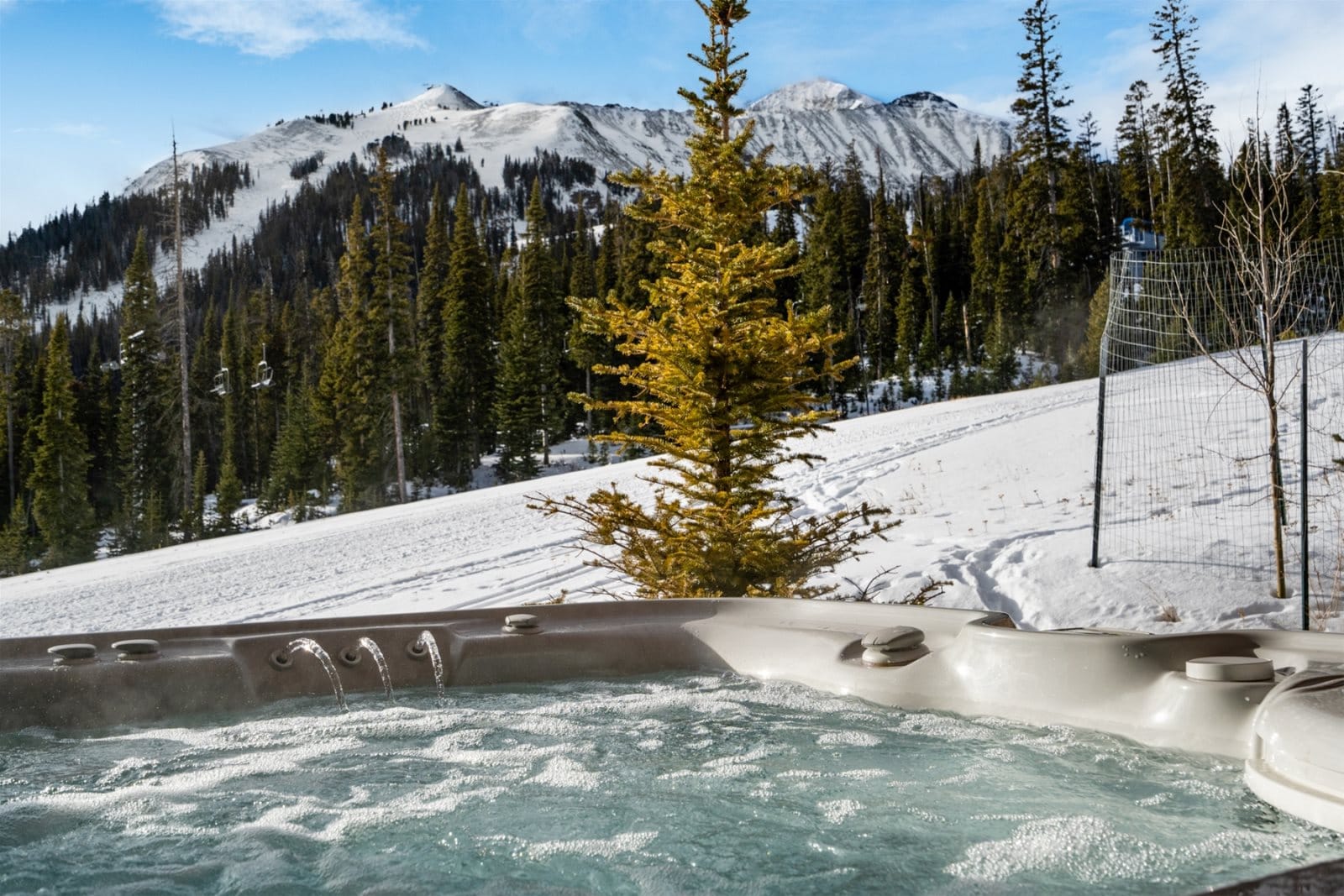 Hot tub with snowy mountain view.